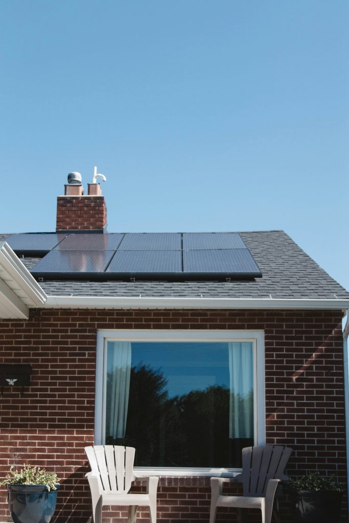 Close look of side of brick home with solar panel on roof